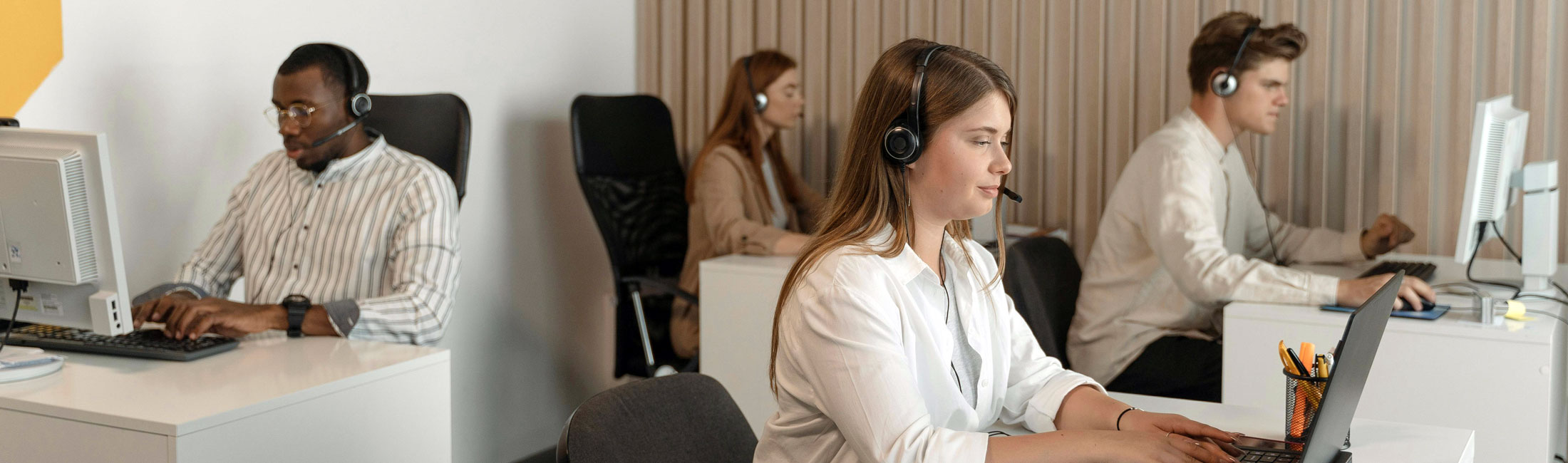 A group of people working inside of a call center.