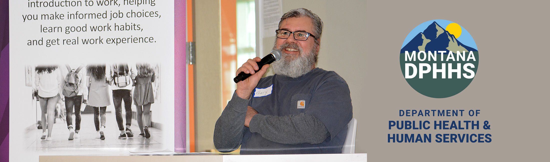 man seated and speaking at conference