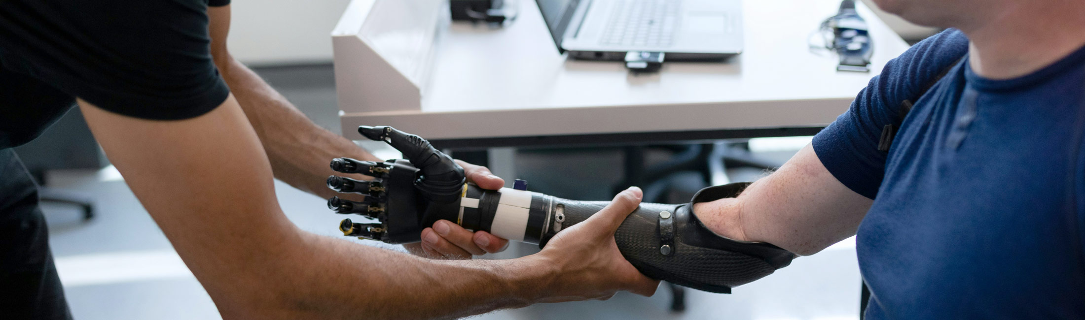occupational therapist works on man's prosthetic arm