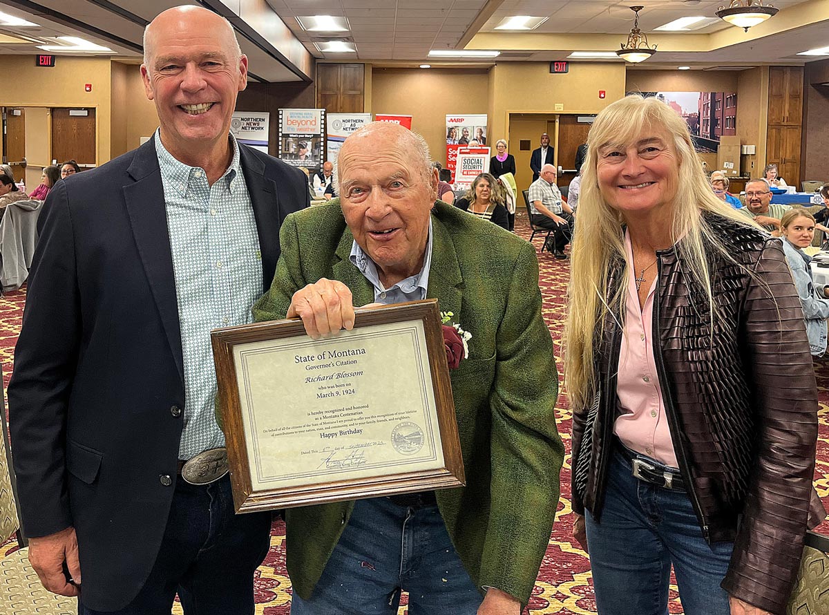 Governor and First Lady standing with man holding certificate