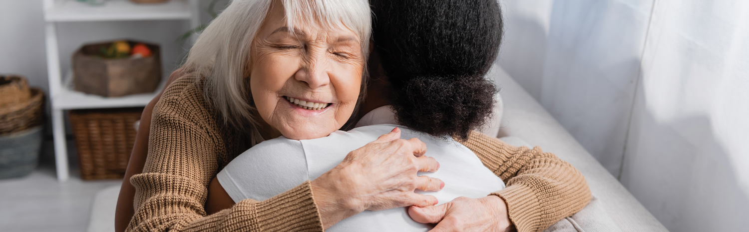 Photo of an elderly woman hugging her caregiver.